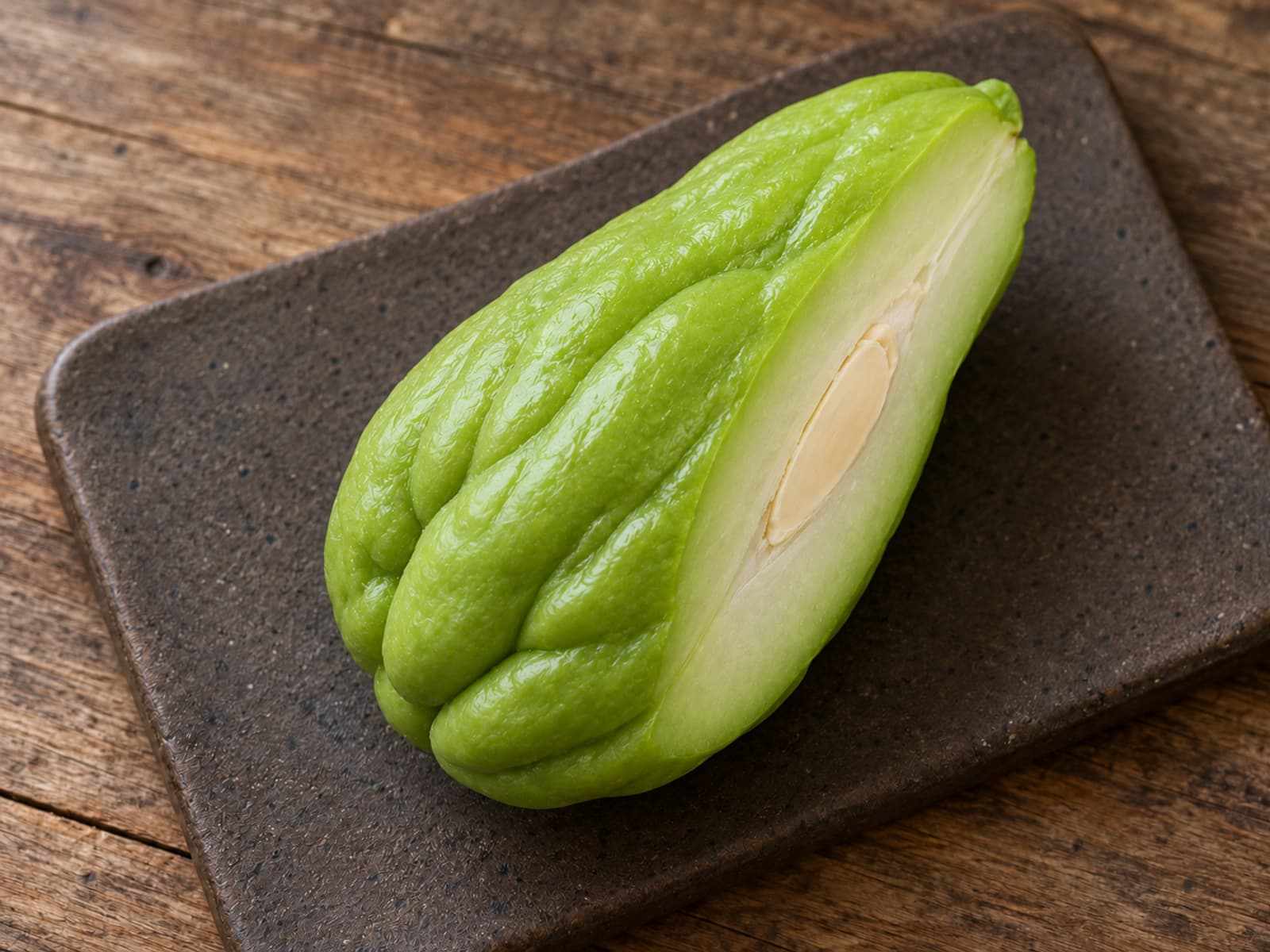 무광 도기판 위 차요테 반쪽의 녹색 주름 골과 옅은 단면